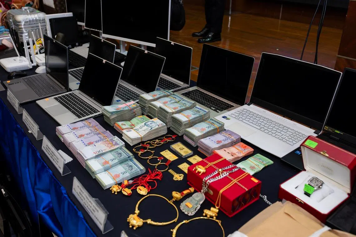 警方在连续两天的突击行动中起获大量各国货币、名表、名牌包、金条，以及手机、笔记本电脑等干案设备。（马新社）