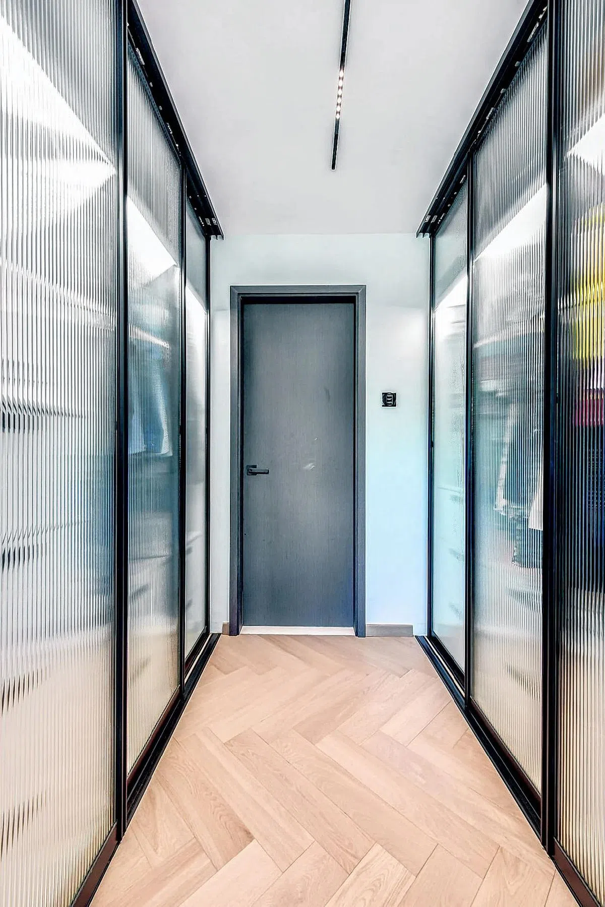 衣柜间风格简单整齐，天然木地板采用人字形铺设，又化简为繁。（idfferent Design Pte Ltd提供图片）