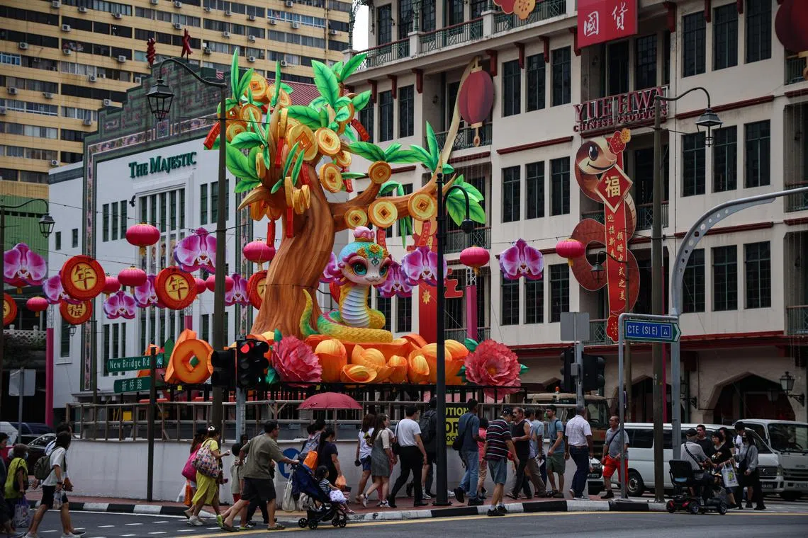 牛车水蛇年主灯造型是一棵8米高的“福树”及一条可爱的大眼金鳞祥蛇，活泼喜气的造型吸引不少公众驻足拍照。（关俊威摄）