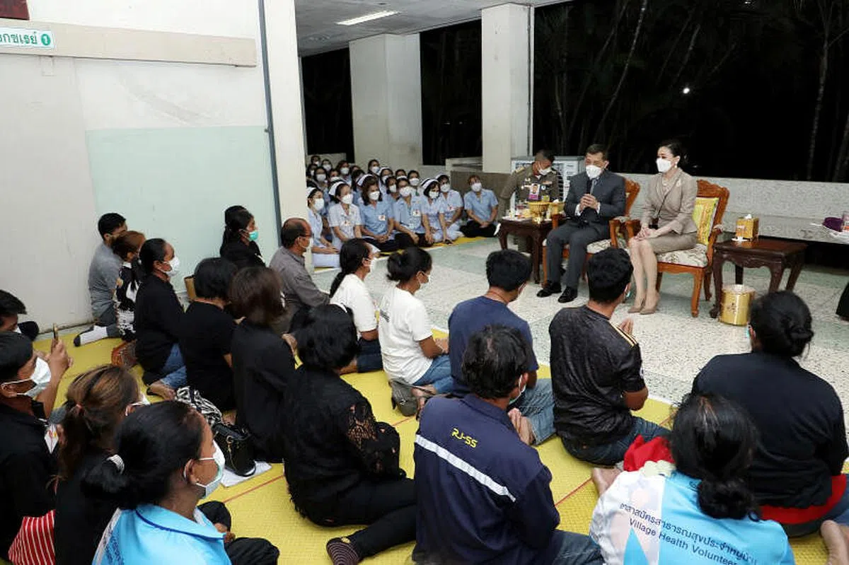 泰王哇集拉隆功（面向镜头右二）告诉遇害者家属，“我会为你们的孩子祈祷，希望你们都能够坚强起来，这样你们的孩子才能够安息。”（路透社）