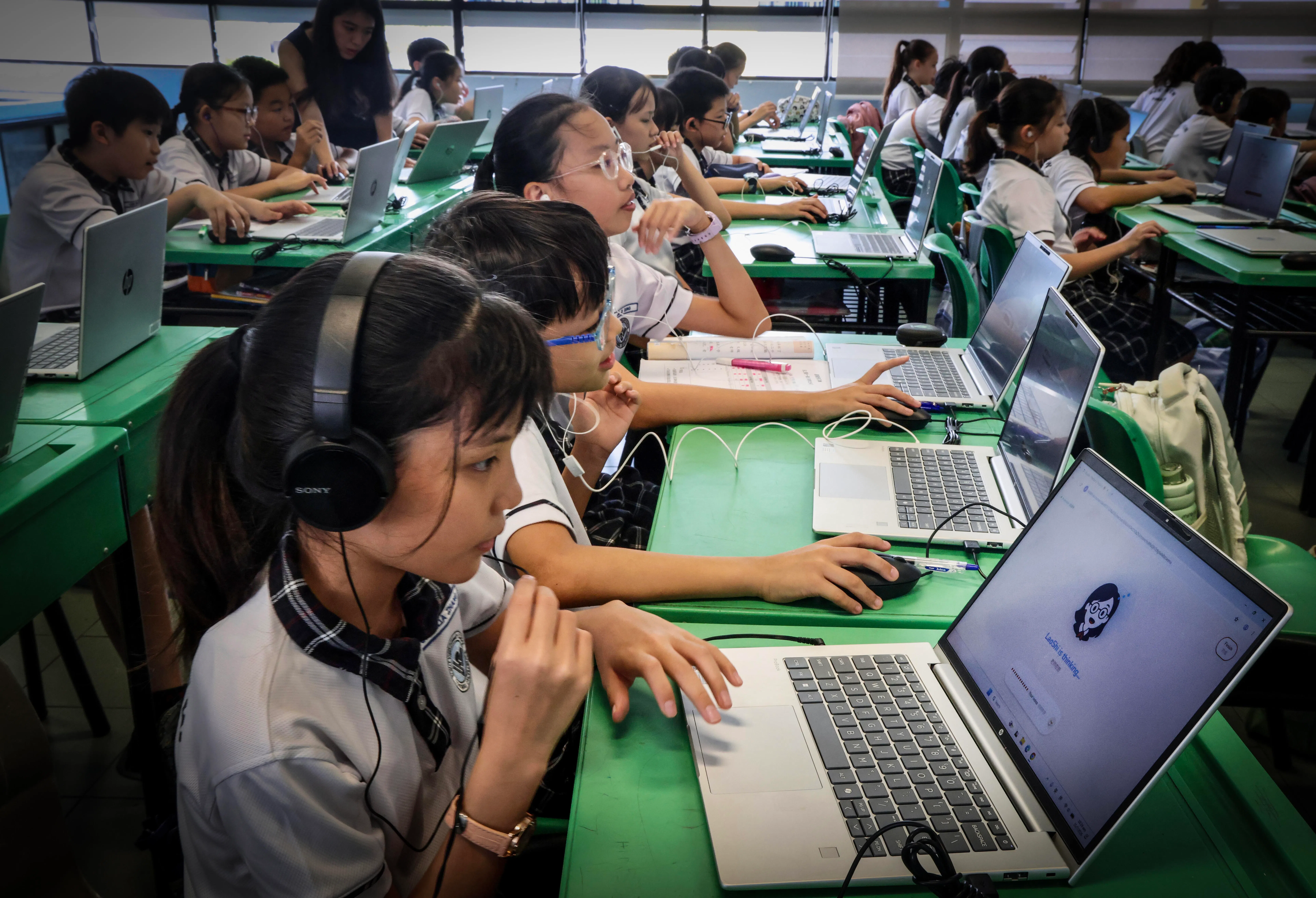 学生在课堂上利用KouShi练习时，老师仍负责引导，并监督和掌握学生的学习进度。（邝启聪摄）