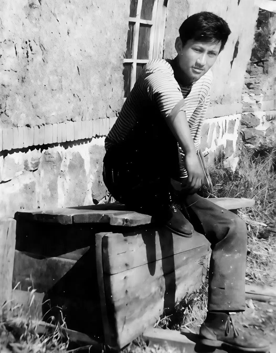 1973年，21岁的金宇澄在黑龙江黑河农场务农，坐在一口新制的棺材上留影（受访者提供）