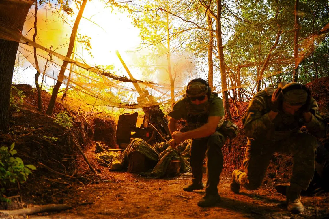 乌克兰士兵星期一在乌克兰东北部哈尔科夫地区一个秘密地点向俄罗斯阵地发射大炮。（法新社）