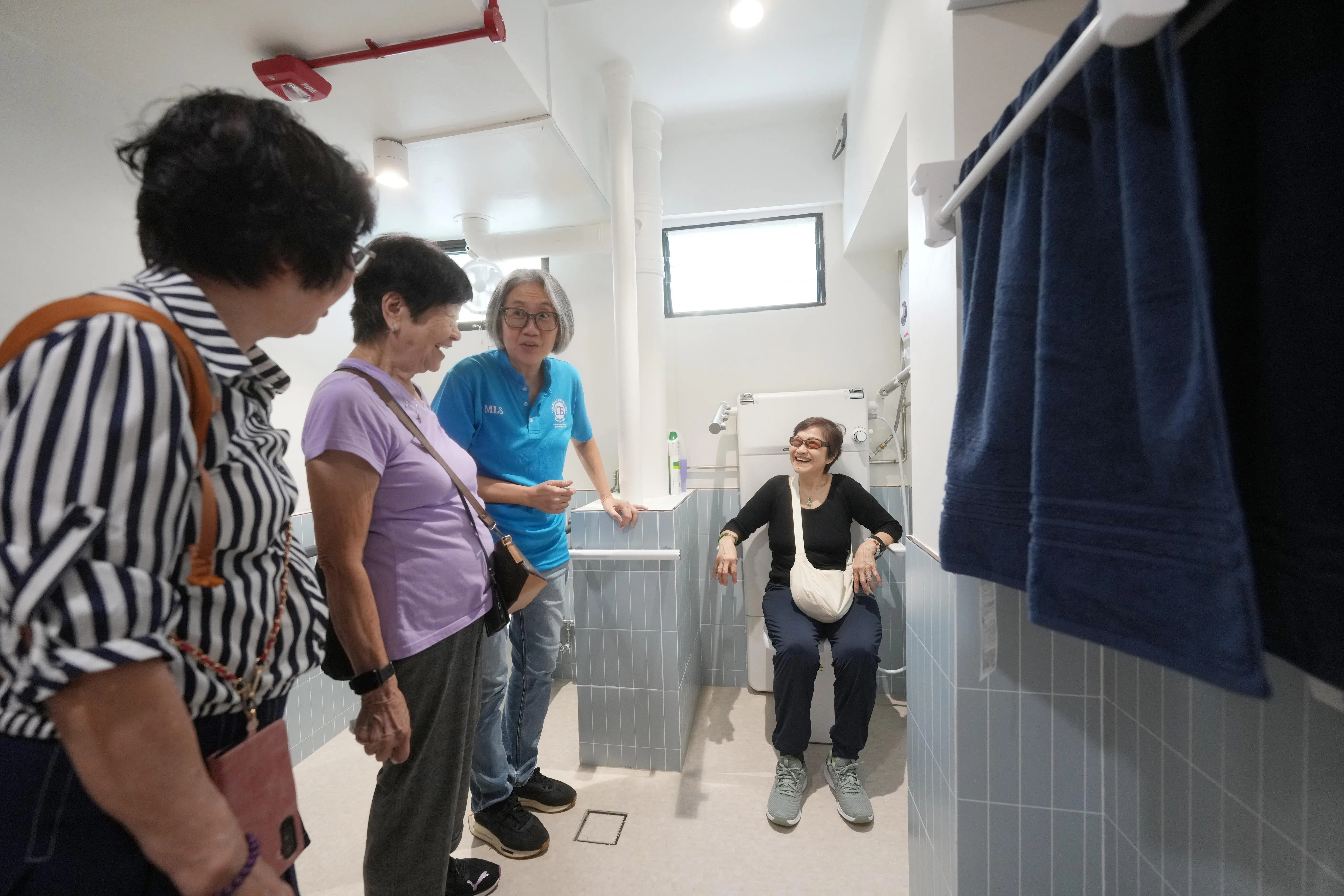 活跃乐龄中心将部分空间布置成“组屋示范单位”，展示亲乐龄科技设备，如坐式水力按摩池；以及有加热功能的浴巾架（右）。（谢智扬摄）