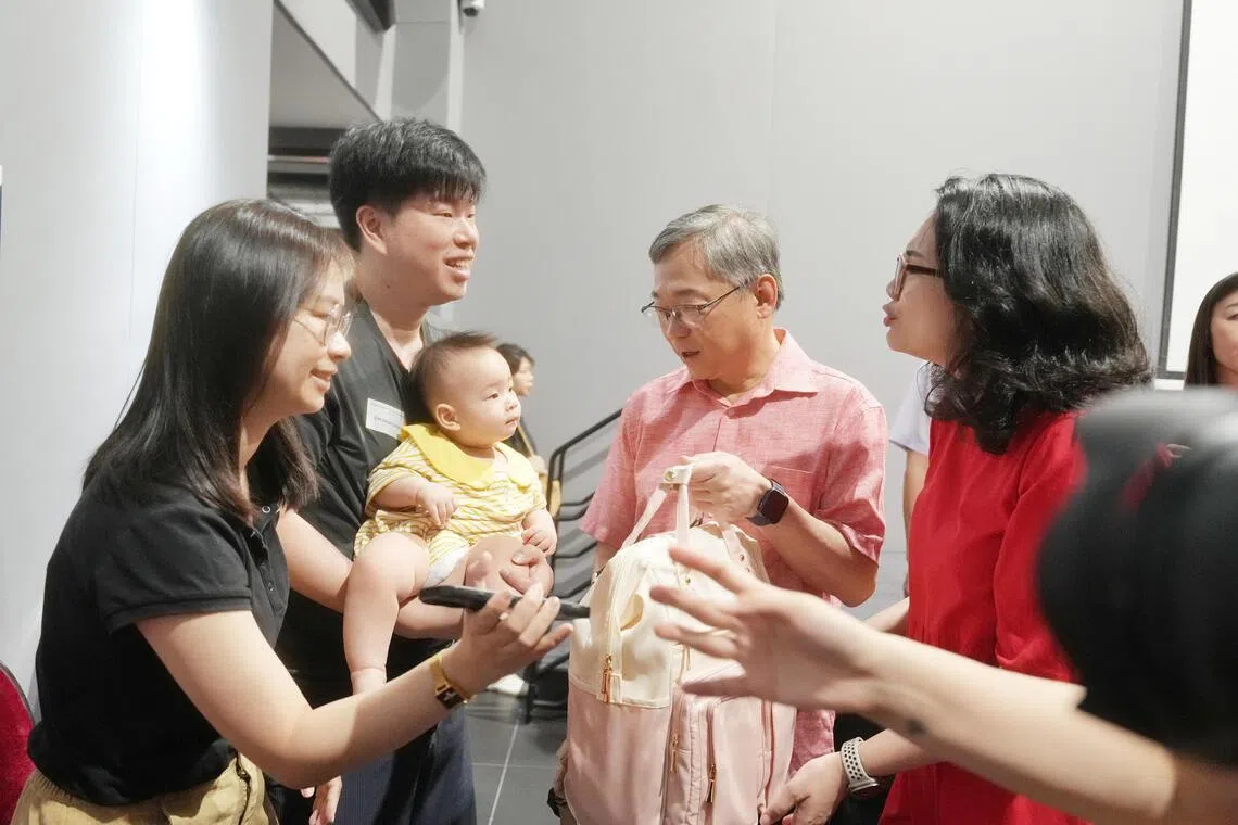 凤山居民沈俊全（左二）与妻子罗巧涵去年9月加入凤山家长俱乐部，夫妻俩星期天带着11个月大的儿子到凤山民众俱乐部参与首场交流会后，与前来观察活动的副总理兼贸工部长颜金勇（右二），以及负责凤山区事务的东海岸集选区议员何礼娜（右一）交谈。（谢智扬摄）