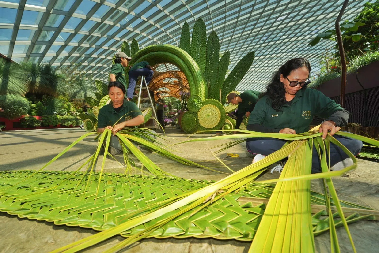 来自峇厘岛的编织团队用树叶编织出印尼的建筑和动物，让走访滨海湾花园的访客感受当地的风俗民情。（谢智扬摄）
