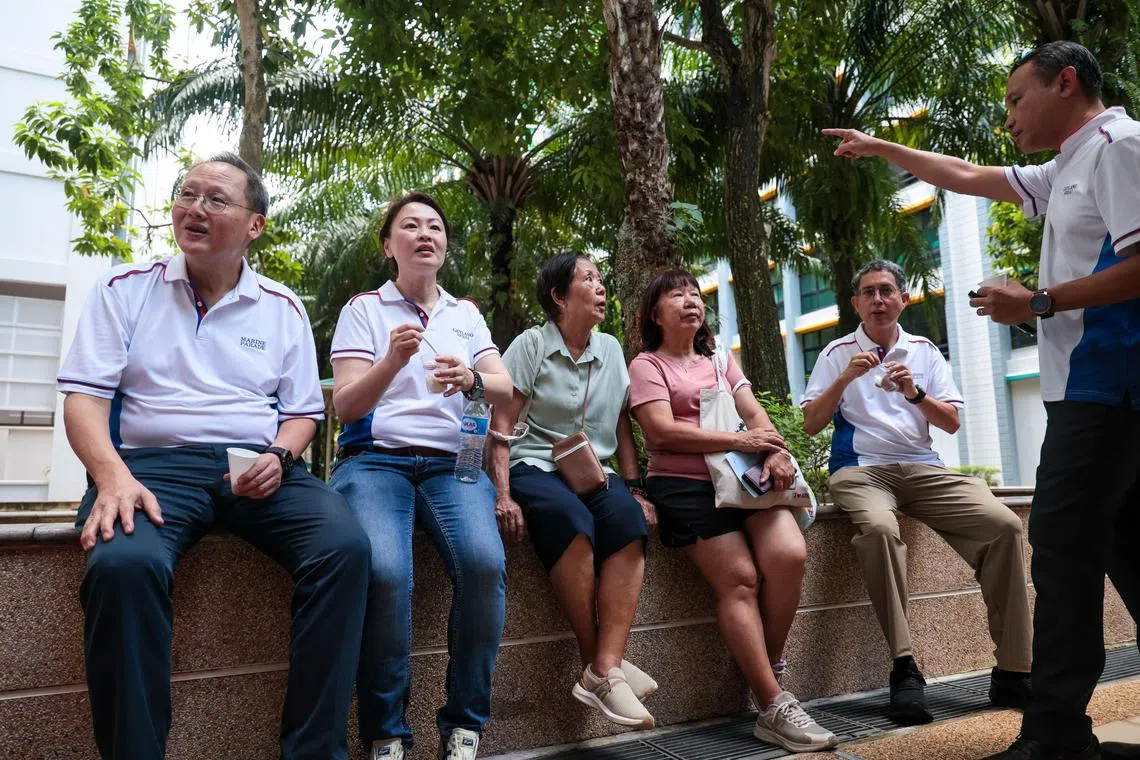 人力部长兼贸工部第二部长陈诗龙医生（左一）、人民行动党新面孔彭丽燕（左二）、内政部兼国家发展部政务部长费绍尔副教授（右二）以及东南区市长阀米（右一）星期六参加“友诺士家庭村嘉年华”，与居民互动交流后，在炎热天气下坐着吃雪糕，歇一歇。（张俊杰摄）