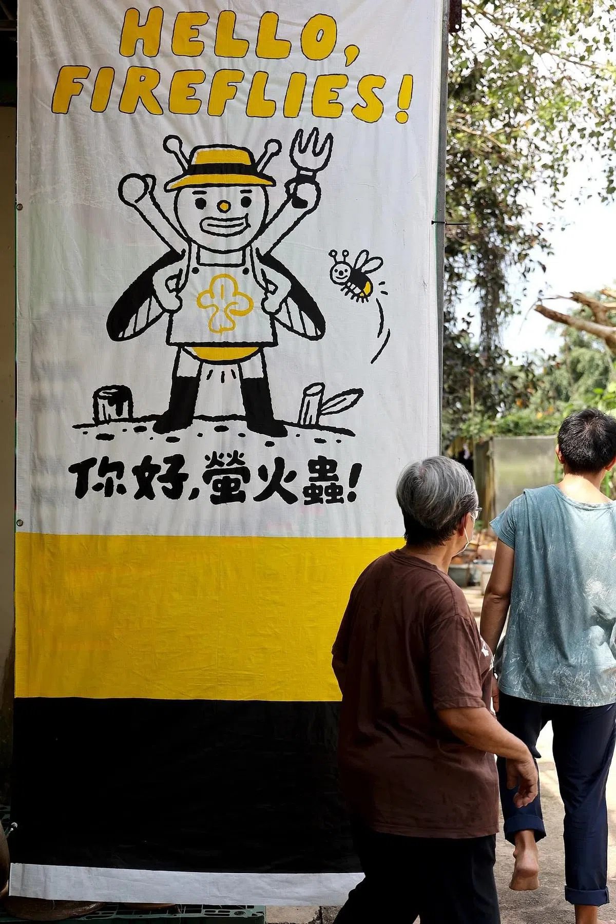 “萤火虫”请本地插画家梁安琪创作绘图，宣传布条今年6月挂上去，期待萤火虫的精神继续燃烧。（龙国雄摄）
