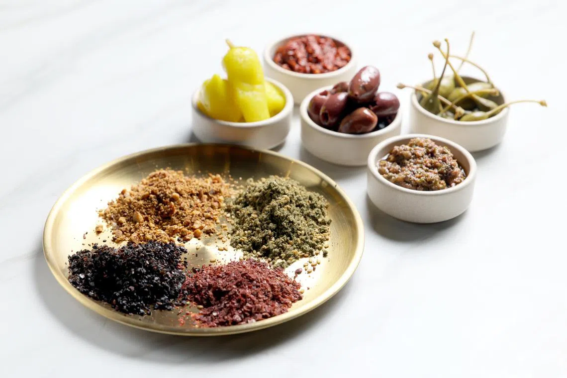 香料是中东菜肴的灵魂。盘中为（左上角，逆时针）杜卡（dukkah）、乌尔法辣椒、盐肤木和扎阿塔尔 (za’atar)。（龙国雄摄）
