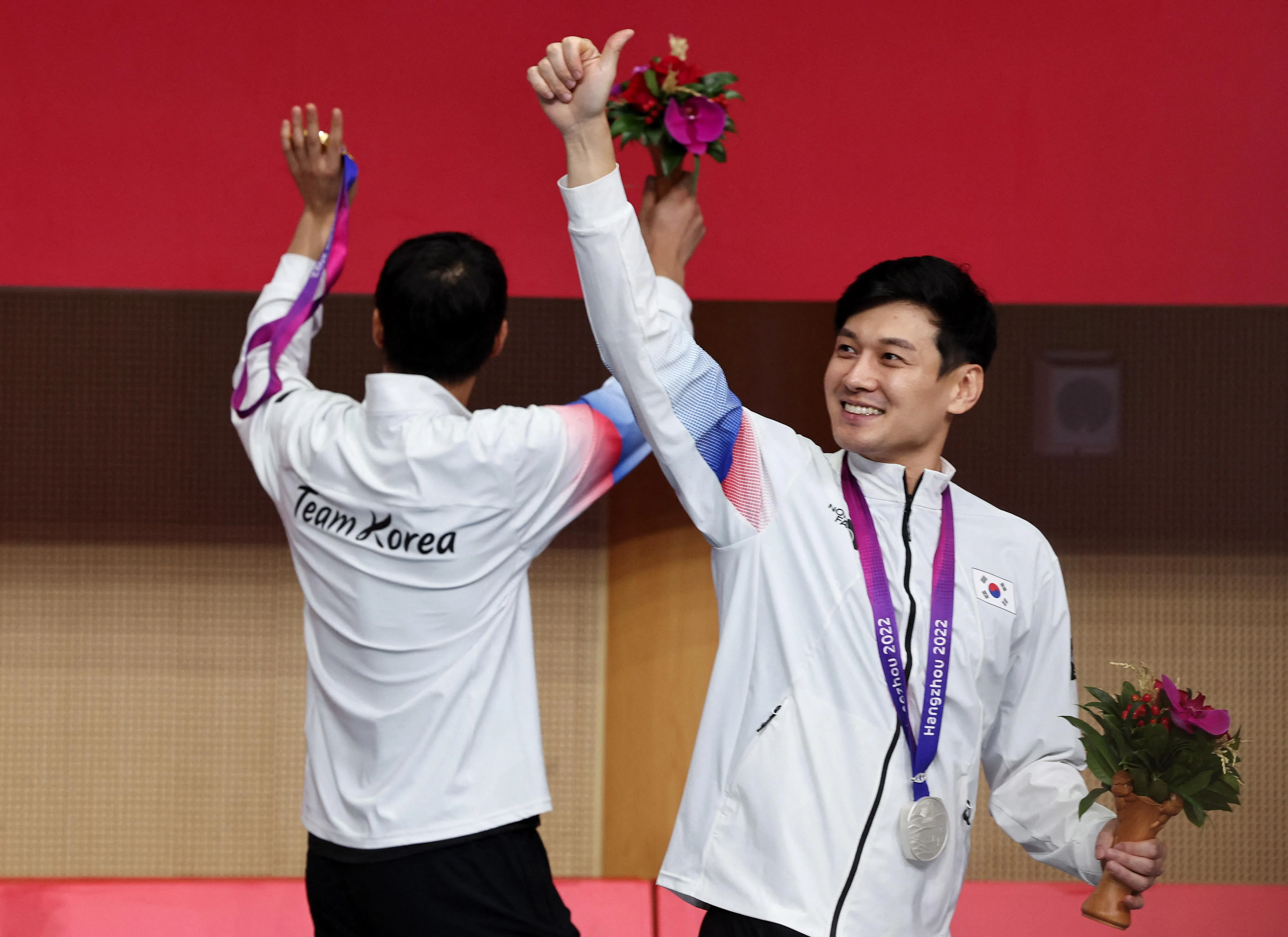韩国佩剑手吴尚旭（前）和具本佶数日前才会师个人赛决赛包揽金银，星期四（9月28日）在团体赛也助韩国卫冕金牌。（路透社）