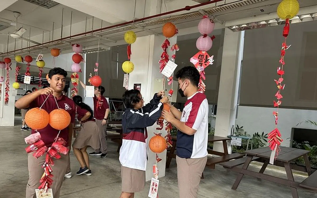 学生忙着把完成的新年挂饰吊起来。（淡滨尼美廉初院提供）
