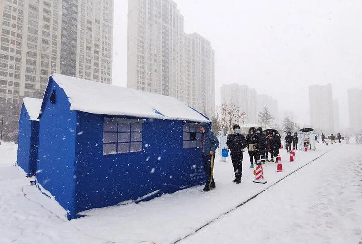 中国新一轮疫情形势严峻。图为吉林省长春市市民本月15日在雪中排队等待核酸检测。（彭博社）