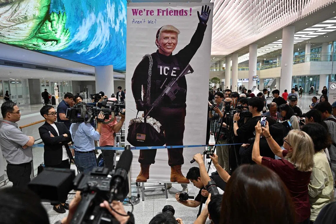 美国拘留韩国工人引发韩国舆论不满，一名抗议者周五在仁川机场立起牌子，上面的美国总统特朗普身穿印有移民与海关执法局（ICE）字样的衣服，旁边写着“我们是朋友！不是吗？”（法新社）