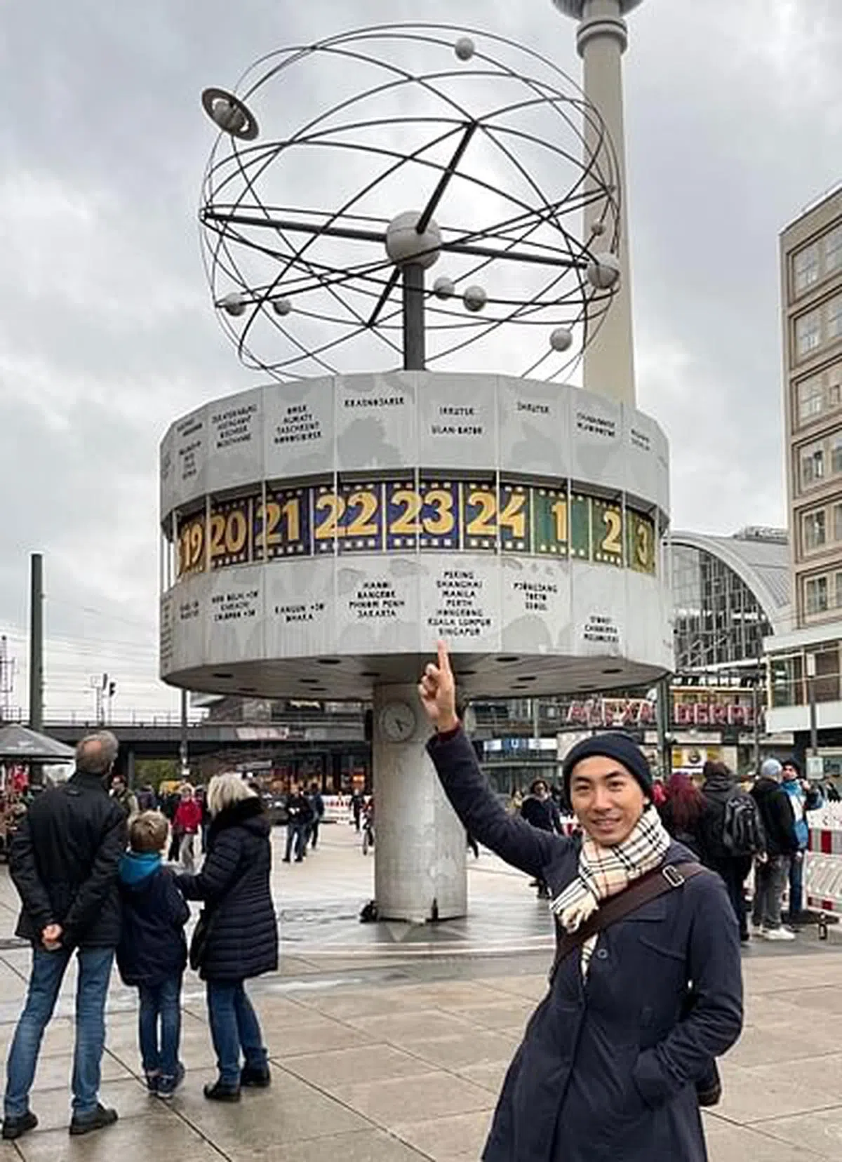 谢顺发一指“撑起”柏林压力山大广场的“世界时钟”。（图/谢顺发提供） 