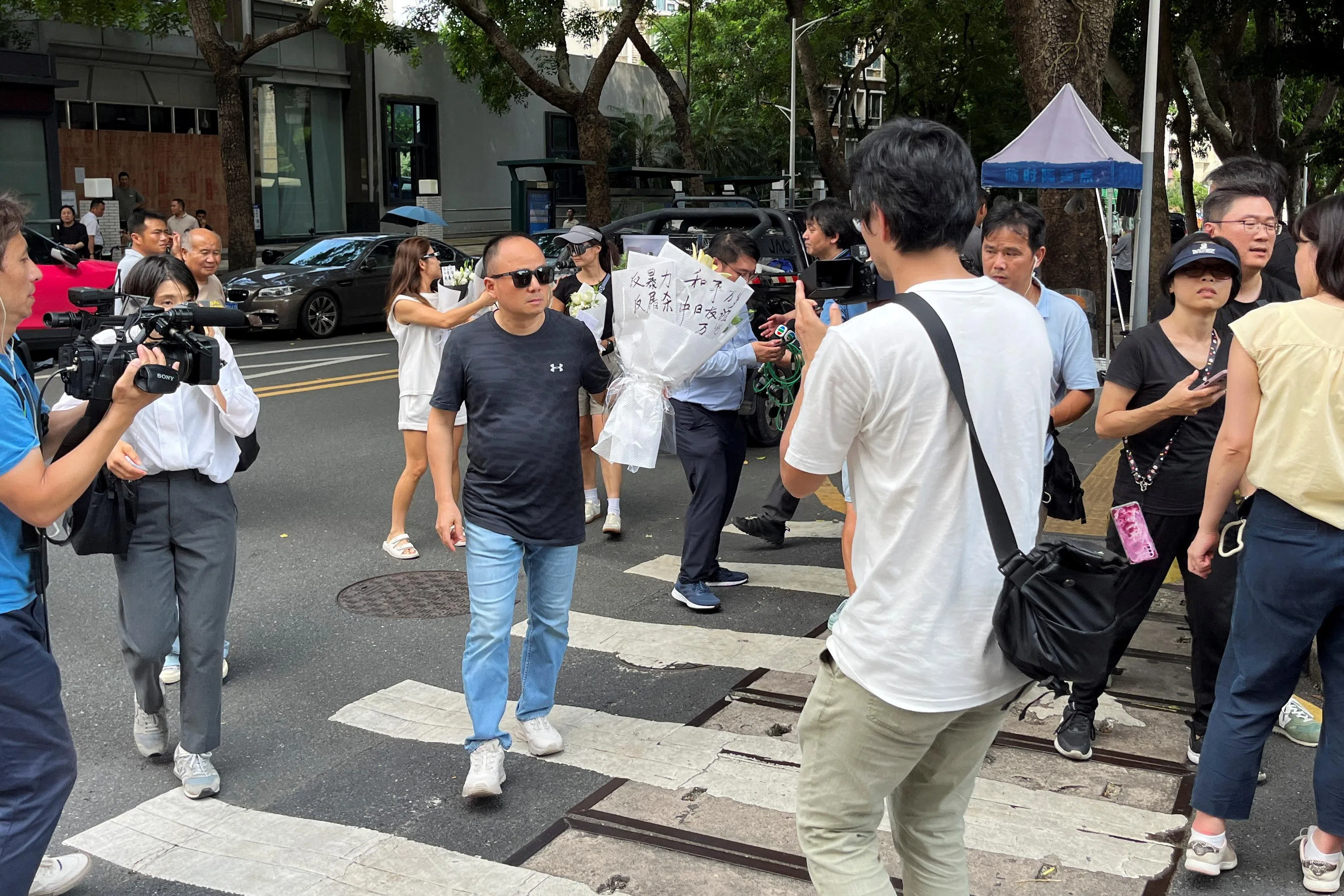 日本男童在深圳遇害后，一名深圳男子星期四（9月19日）手持鲜花到案发地深圳日本人学校献花。（路透社）