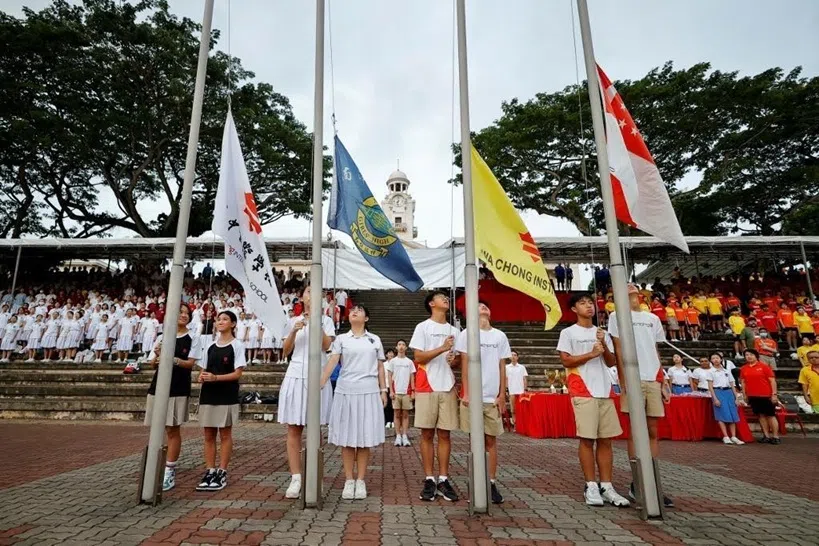 华侨中学国际部（左起）、南洋女子中学校和华侨中学中学部的低年级学生在华侨中学的操场举行升旗仪式。（南中提供）