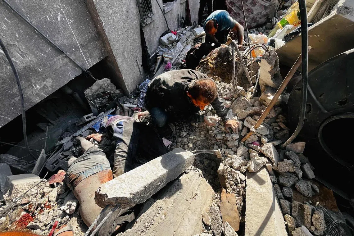 以色列轰炸拜特拉希亚的居民楼致至少93人死亡，民防人员设法搜寻受困废墟下的大约40个居民。（法新社）