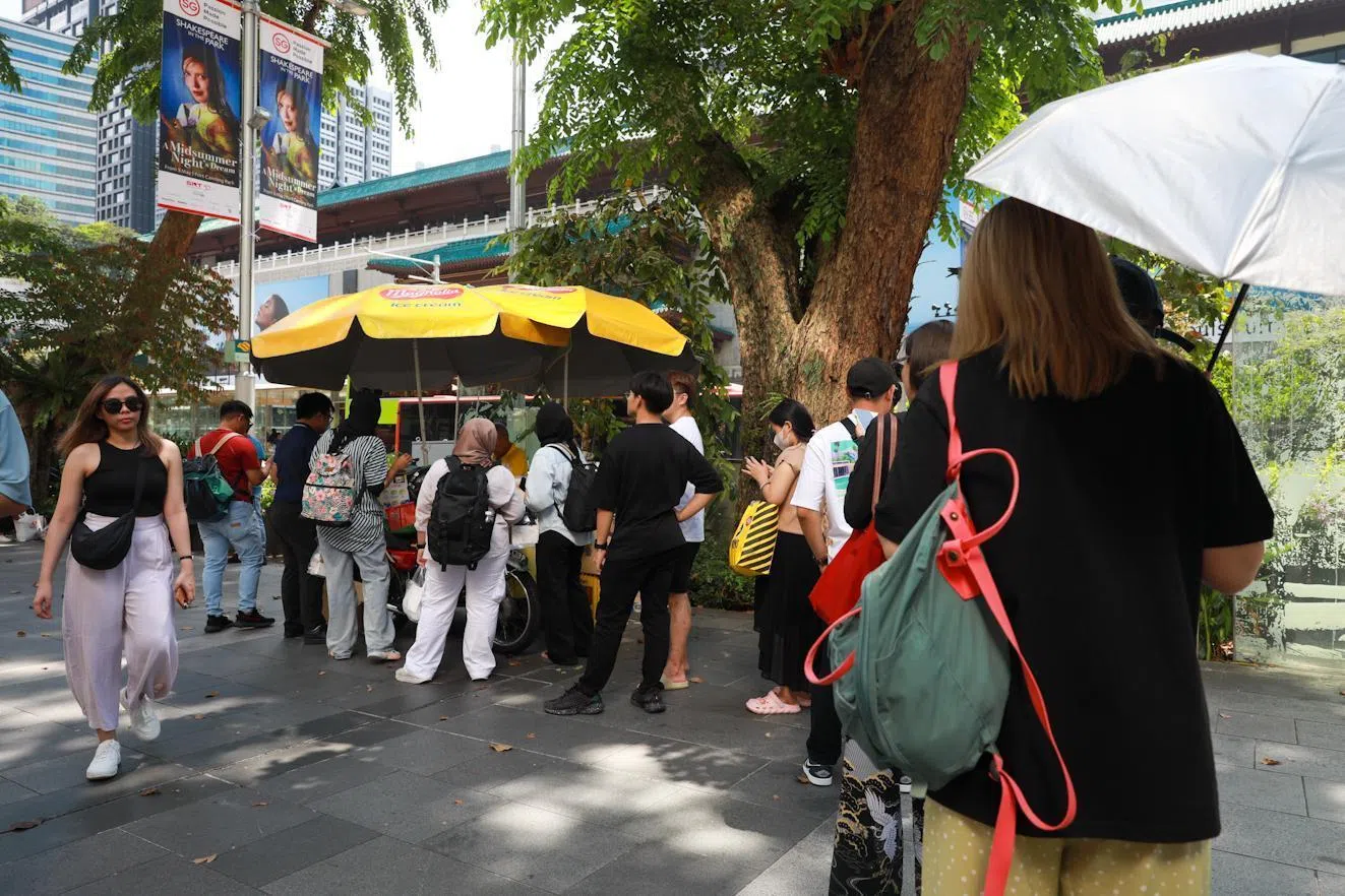 新加坡天气炎热，冰淇淋推车前可见排起长龙的人潮。这道街头甜点也出现在不少游客到访本地时的“必吃清单”里。（张俊杰摄）