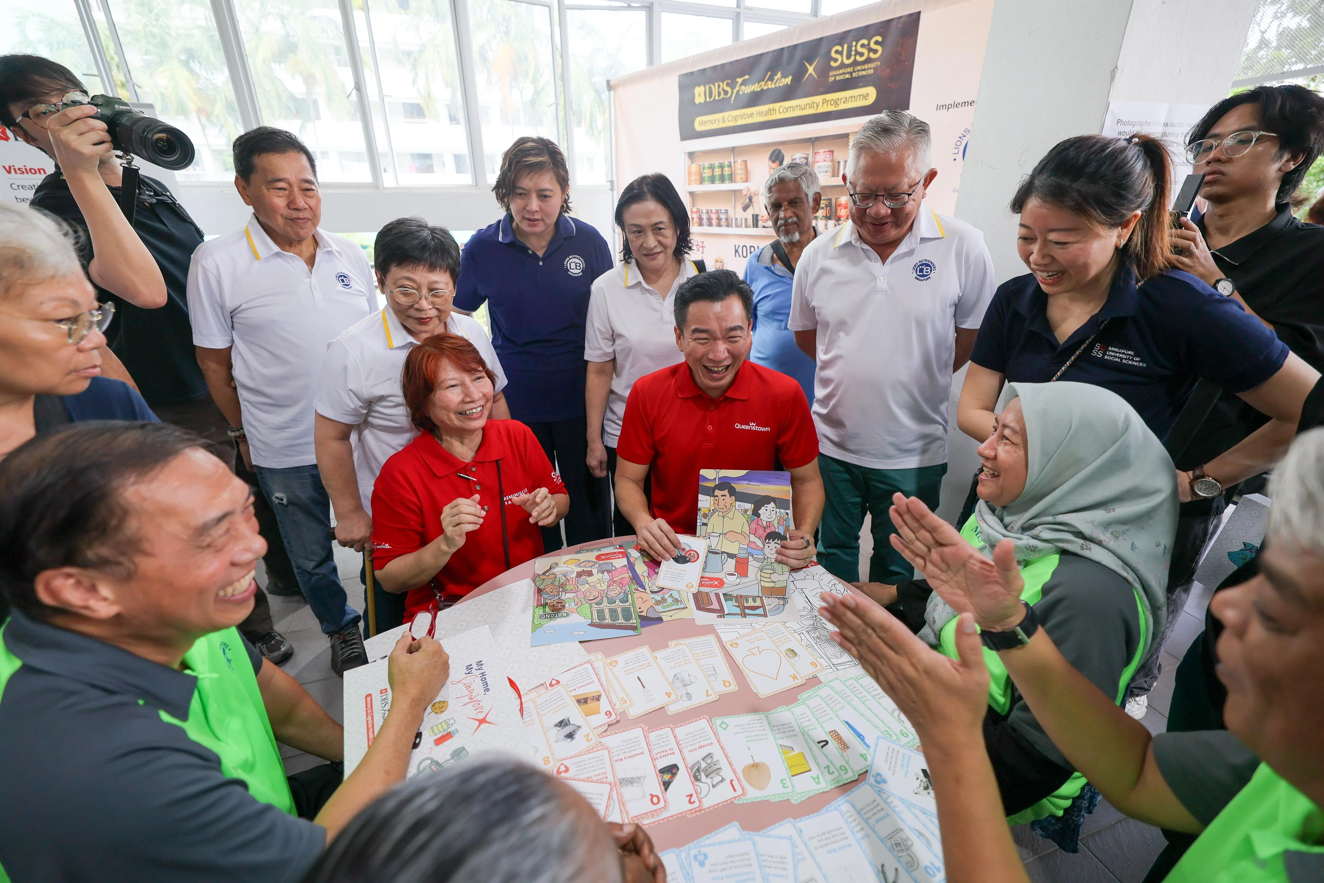 何萨拉（前排左二）向律政部兼社会及家庭发展部高级政务次长蔡瑞隆（前排左三）介绍游戏卡。（张俊杰摄）