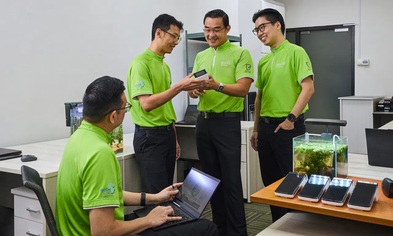 DCS Synthesis founder Jimmy Teo speaking with employees in the company’s office.