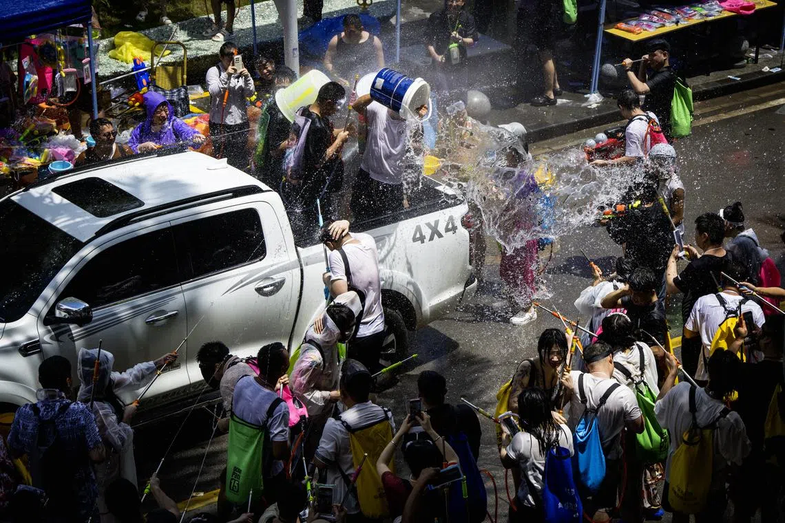 路过的小货车，猛烈回击路旁的泼水战队。（蔡光发摄）