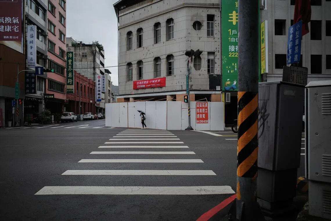 台中的十字路口，行人的身影在斑马线上匆匆掠过，仿佛横跨着过去与未来。（叶振忠摄）