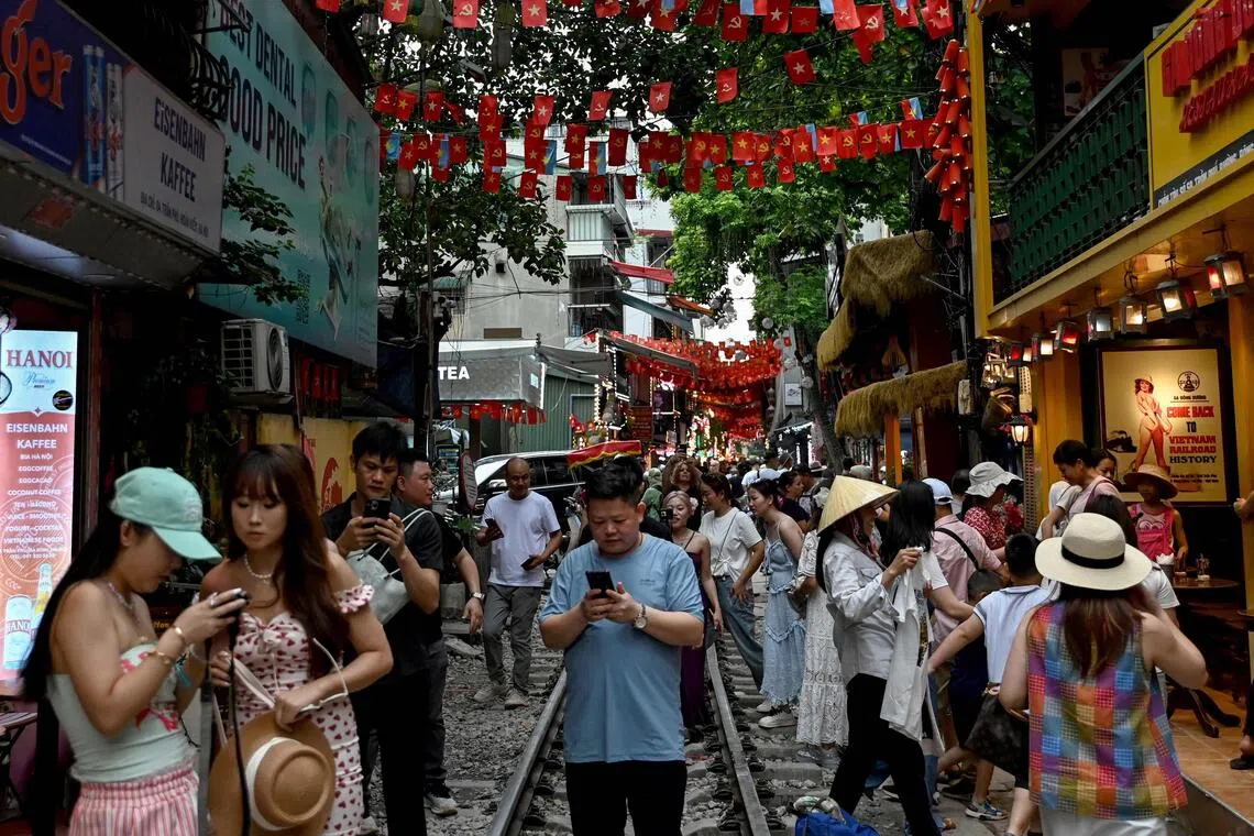 “火车街”虽有特色，但火车轨道上经常挤满拍照打卡的游客，造成安全隐患。（法新社）