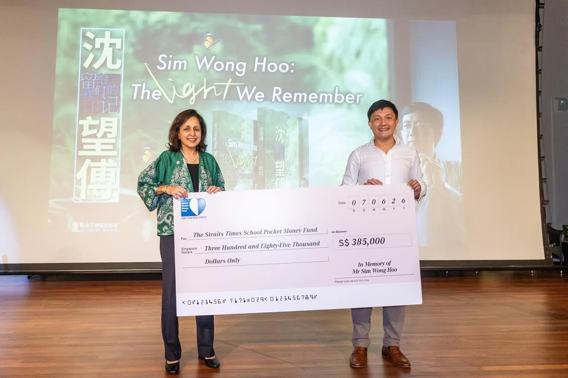《海峡时报》副总编辑卡兰吉·考尔（Karamjit Kaur）（左）代表《海峡时报》学校零用钱基金，从沈望傅的侄儿、现任创新科技首席执行官沈立恩手中接过38万5000元的捐款支票。（吴先邦摄）
