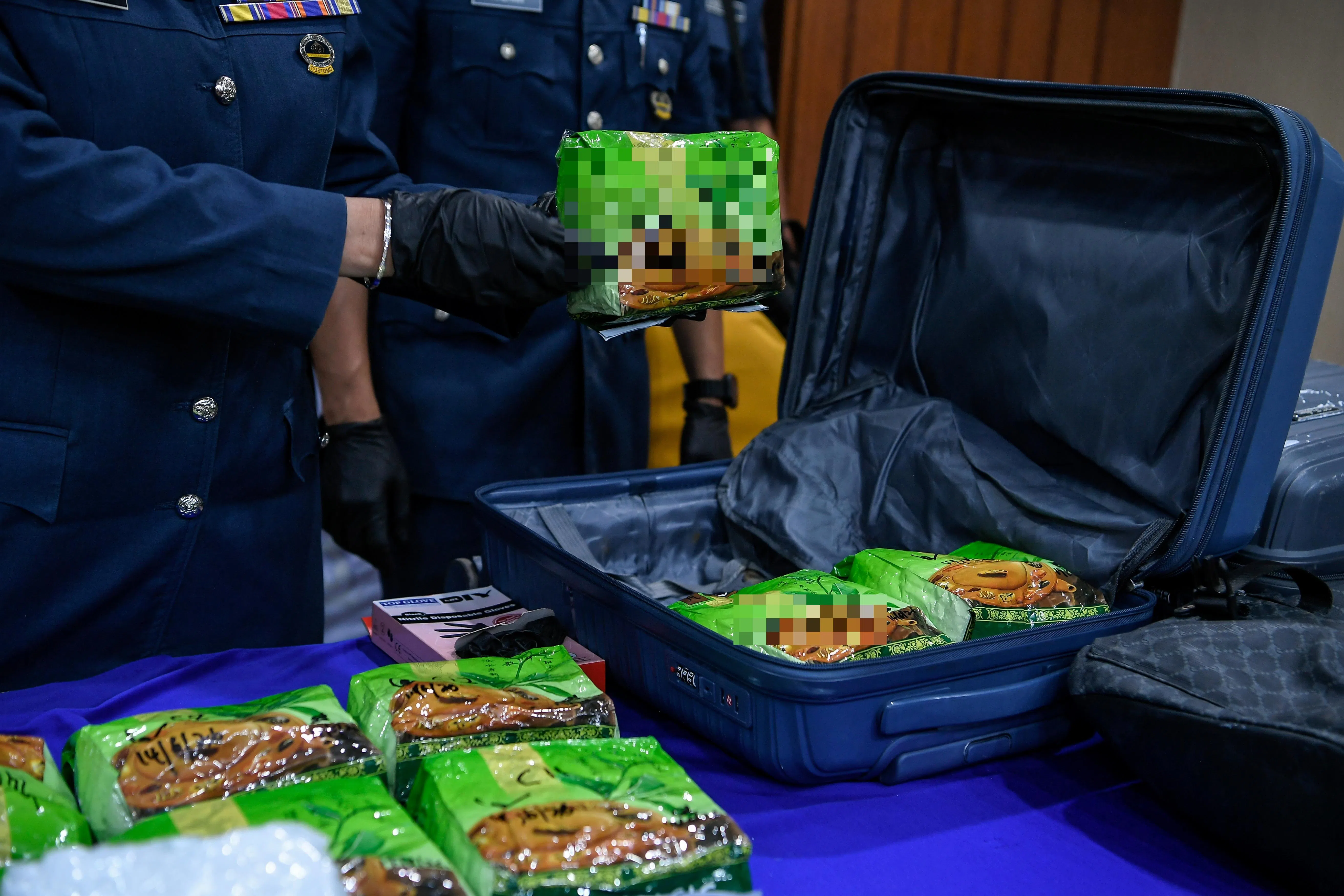 嫌犯将装有毒品的行李箱和背包抛入海中企图毁灭证据，但被执法人员成功捞起。（马新社）
