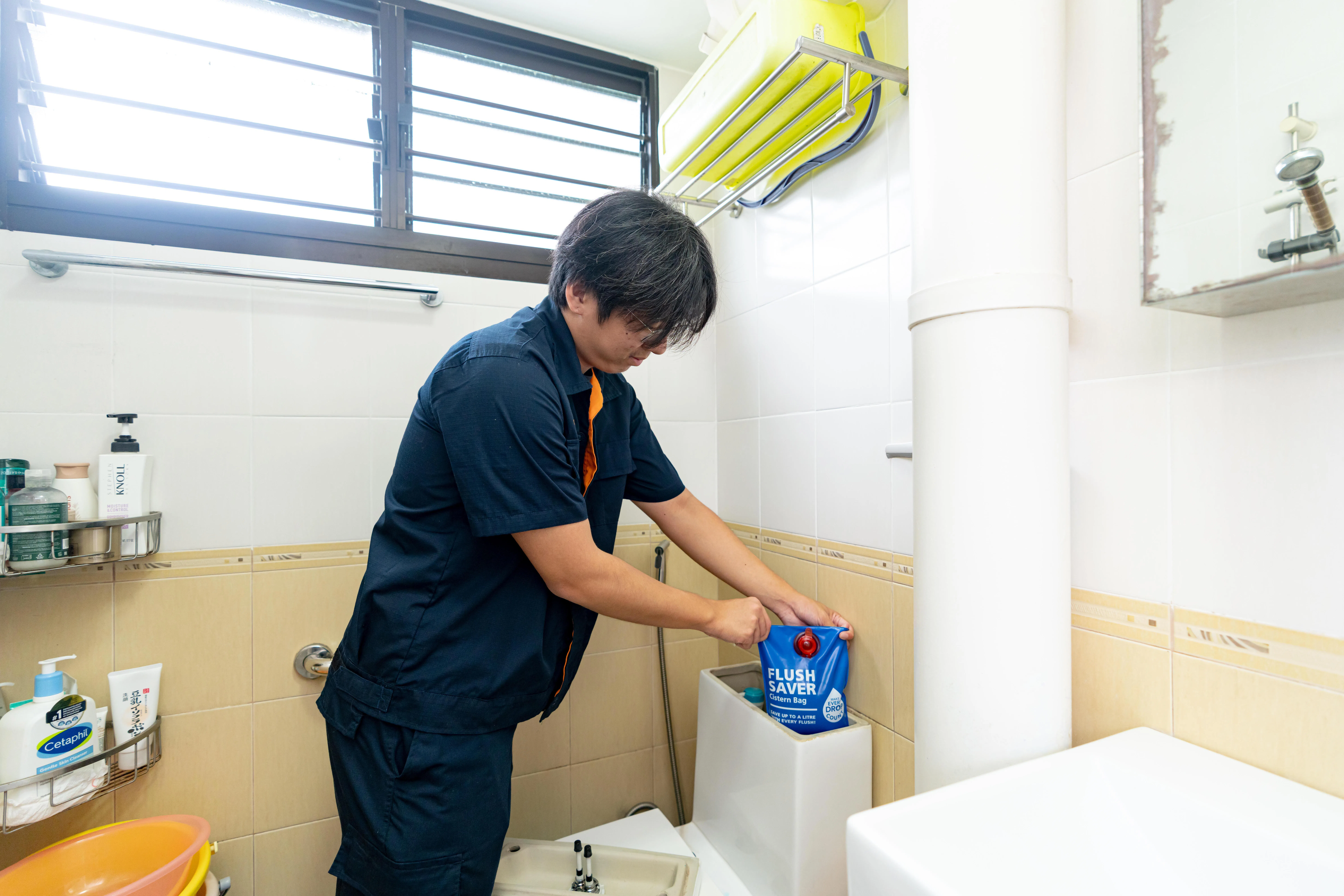 工艺教育学院应公用局邀请，让学生协助蔡厝港72户家庭安装由当局开发的马桶水箱节水袋，帮助居民节省用水。（公用事业局提供）