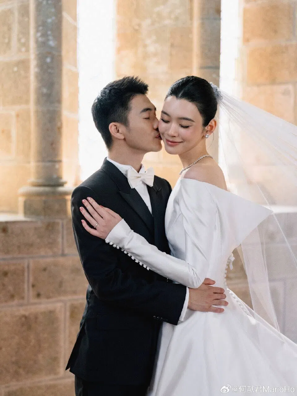 何猷君（左）和奚梦瑶在婚礼上拥吻，尽显甜蜜。（取自何猷君微博）