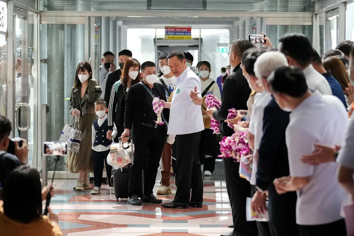 载有中国游客的厦门航空星期二（1月9日）落地泰国。泰国副总理兼卫生部长阿努廷（中）到机场迎接，向入境旅客献花。（路透社）