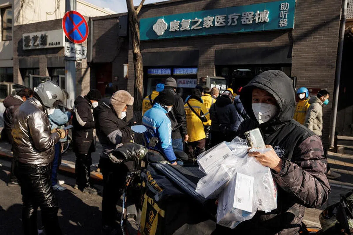北京一名送货员12月7日从一家药房提取一堆药物。（路透社） 