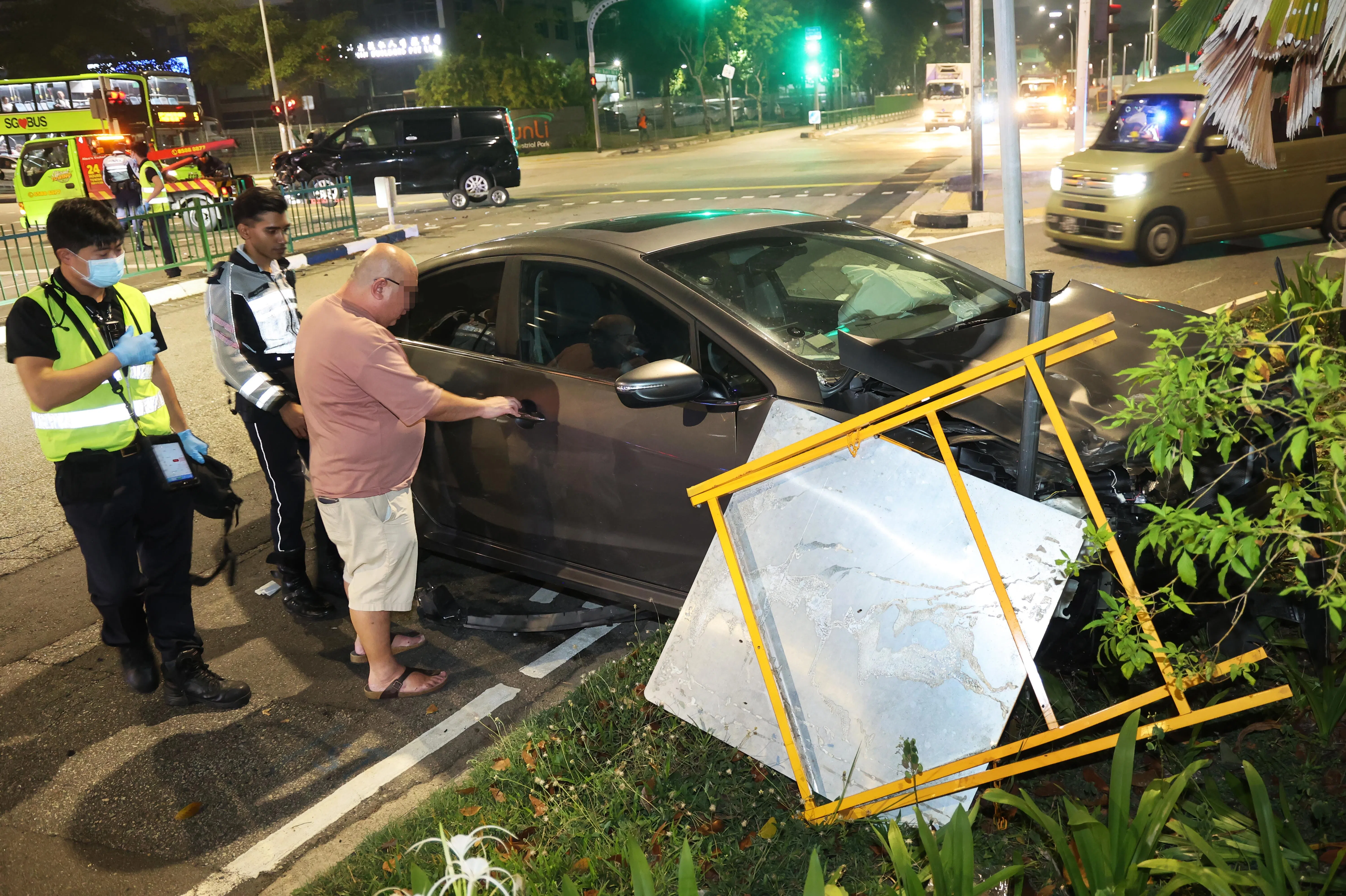 银灰色汽车冲上路边草坪。（蔡振鸿摄）