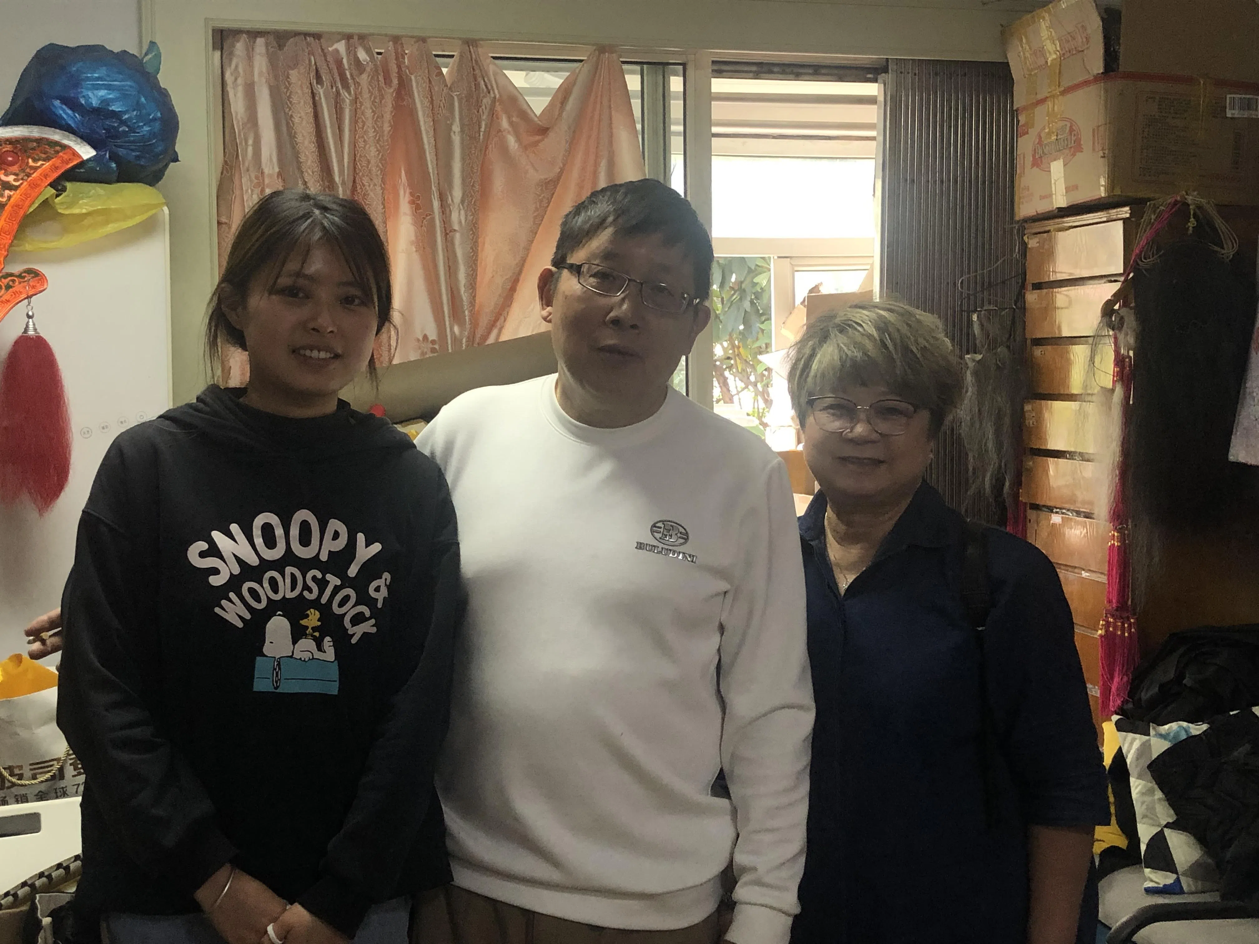 上海戏剧服装用品制作师傅李肖民（中）和女儿（左）在浦东杨高南路经营工作坊，制作和出售各种戏曲用品。与他们合影的是南华副执行总裁陈巧香。（谢燕燕摄）
