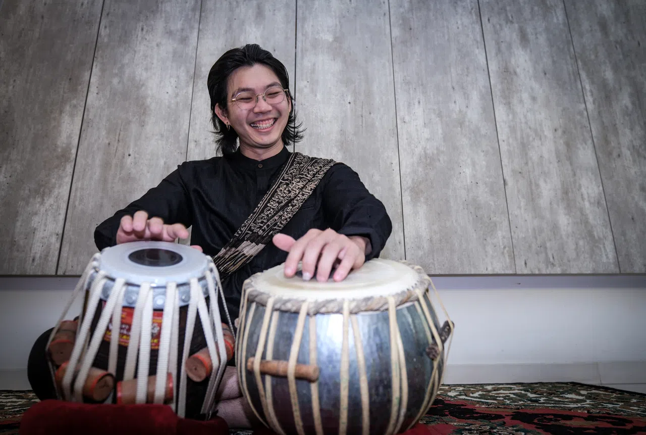 Govin Tan, dressed in traditional Indian attire, plays the tabla drums.