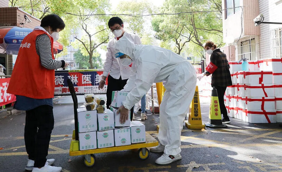 社区志愿者4月11日将完成酒精消杀的生活物资装运到派送小推车上。（新华社）