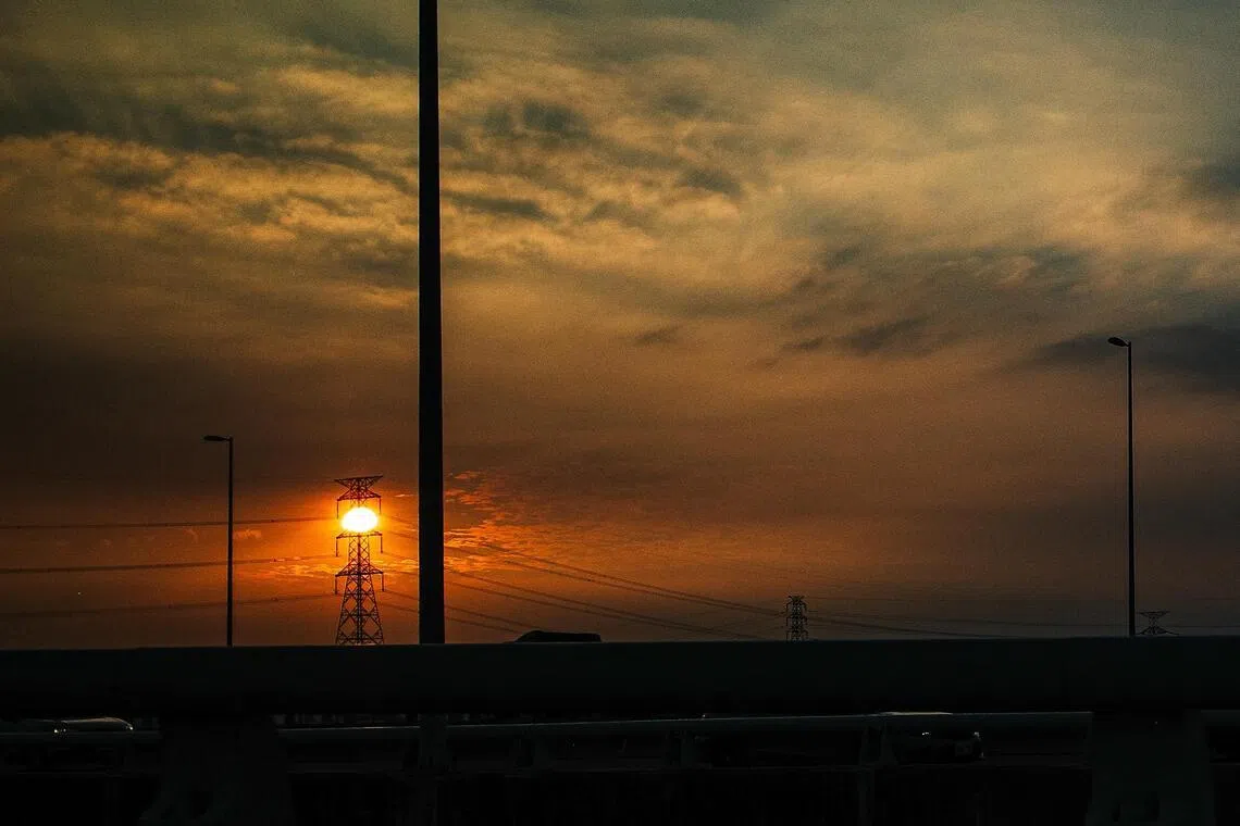 电塔坠入夕阳怀抱，点亮城市黄昏。（叶振忠摄）
