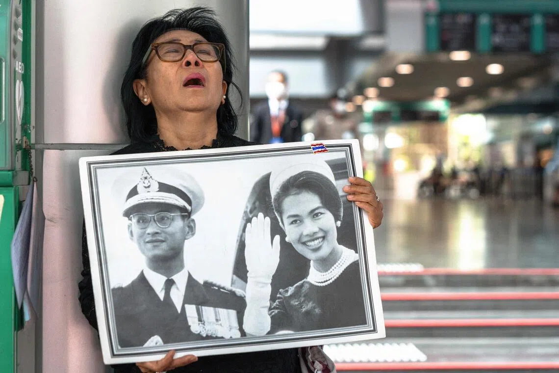 泰国王太后诗丽吉被誉为“泰国人民的母亲”，深受国民爱戴。她周五晚在朱拉隆功医院病逝，一名女子隔天手持诗丽吉和已故泰王蒲眉蓬年轻时的照片到医院哀悼，难掩悲痛。（法新社）