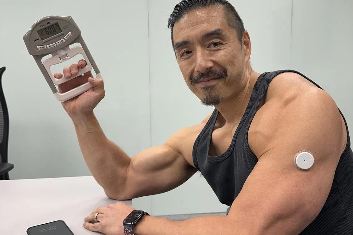 何鼎手臂上穿戴着全天血糖测量仪，这些记录有助于收集更准确的生物标记，了解“代谢开关”。（苏秉苓摄）