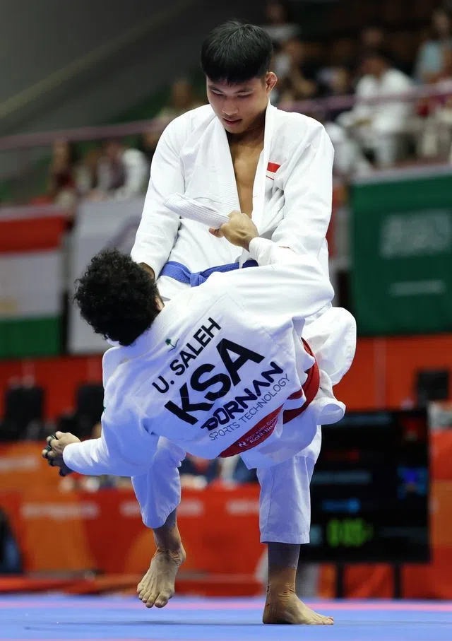 我国19岁小将陈世杰（上）在男子77公斤级32强赛中，以优势分淘汰沙特阿拉伯好手萨利赫。（新加坡全国奥理会提供）