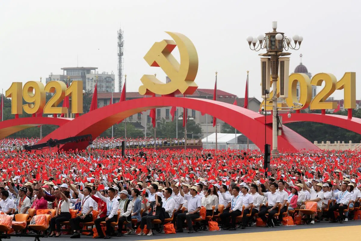 中共党庆大会参与者在北京天安门广场挥举中国国旗和中共党旗。（路透社）