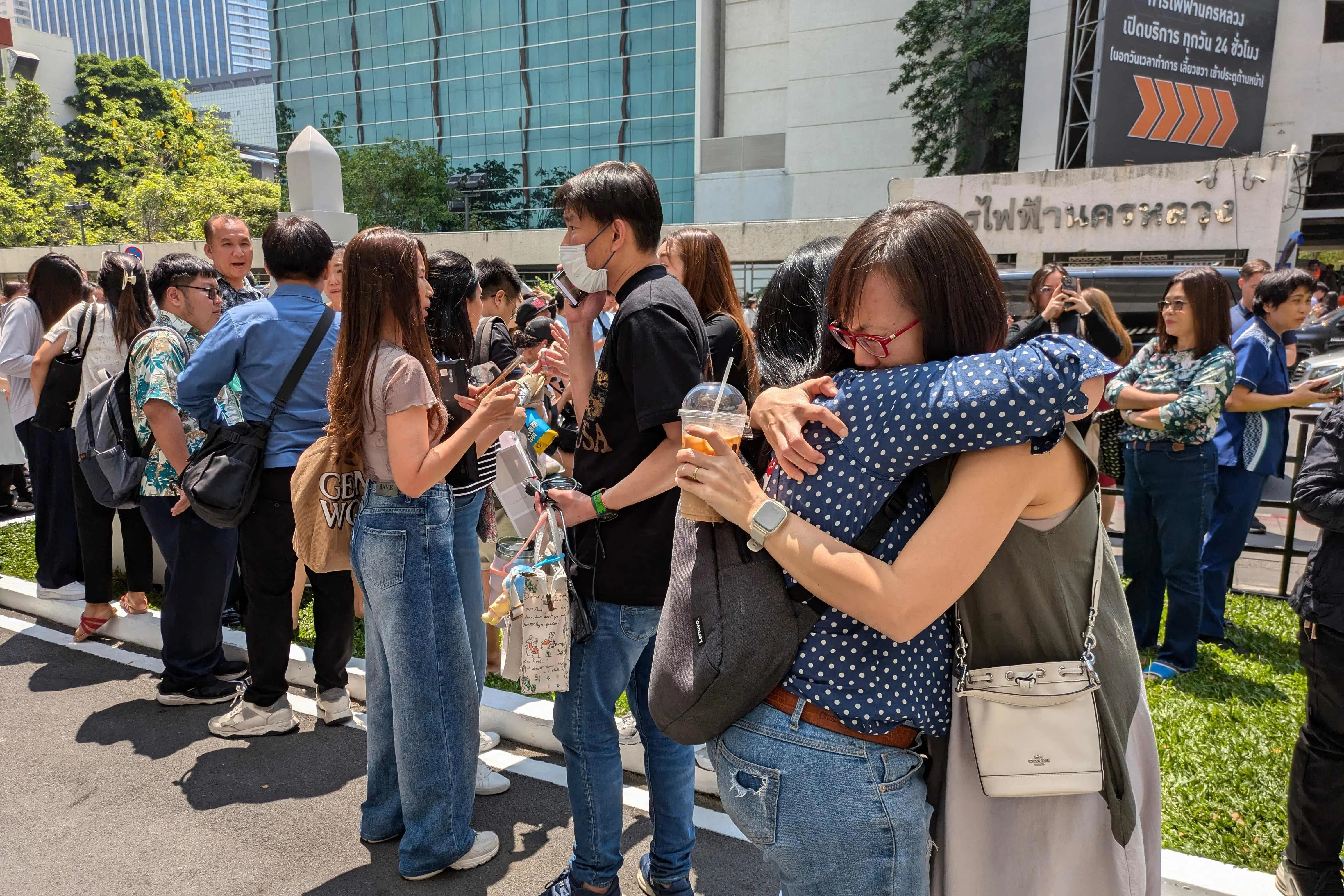 强烈的摇晃促使曼谷市一栋办公楼的民众急忙跑到街上避难，一些人惊吓过度相拥而泣。（法新社）