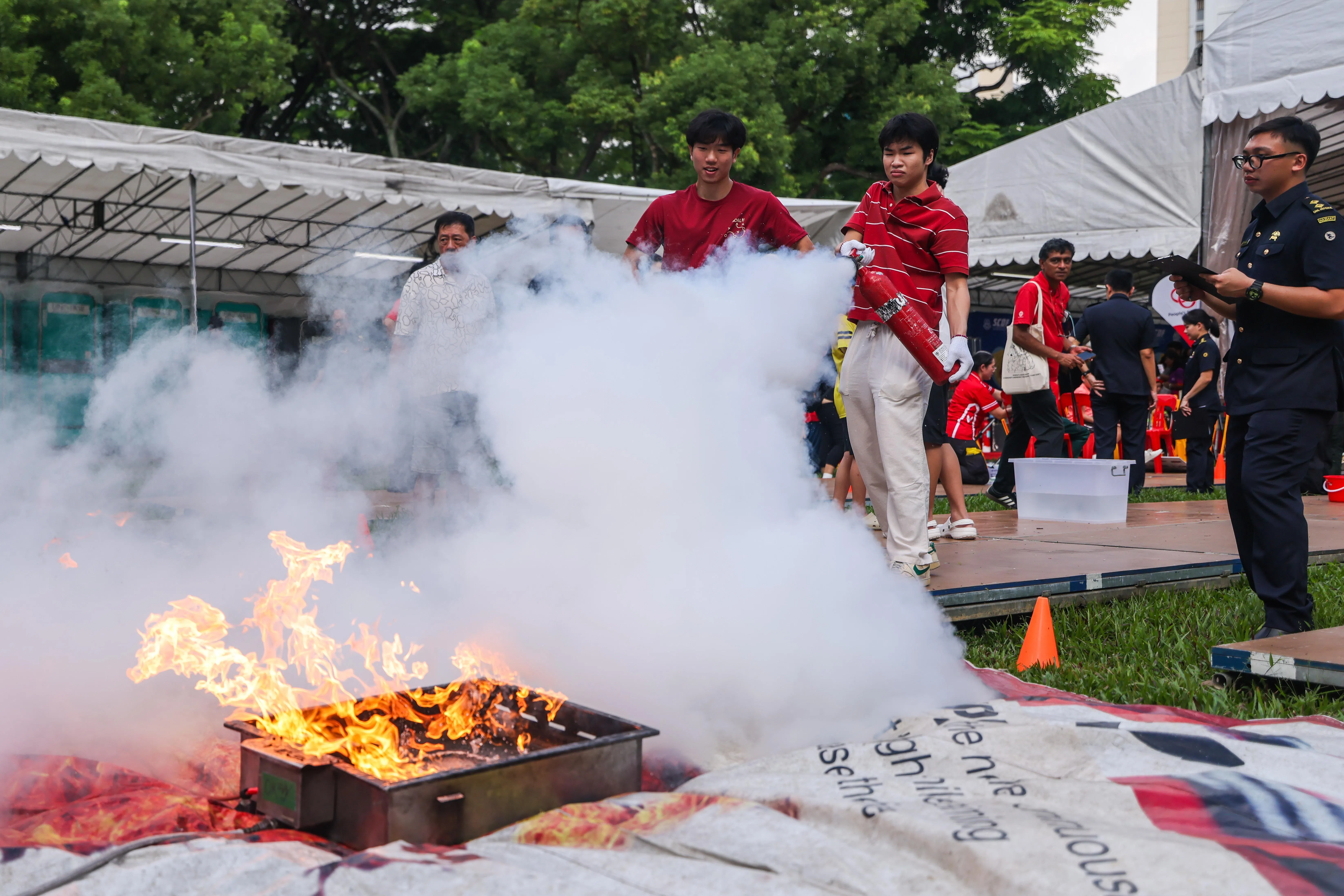 社区里的男女老少配合新加坡民防部队、新加坡警察部队，以及阿裕尼后港社区紧急应变小组的义工等，在活动现场展开火患安全应急竞赛。（白艳琳摄）
