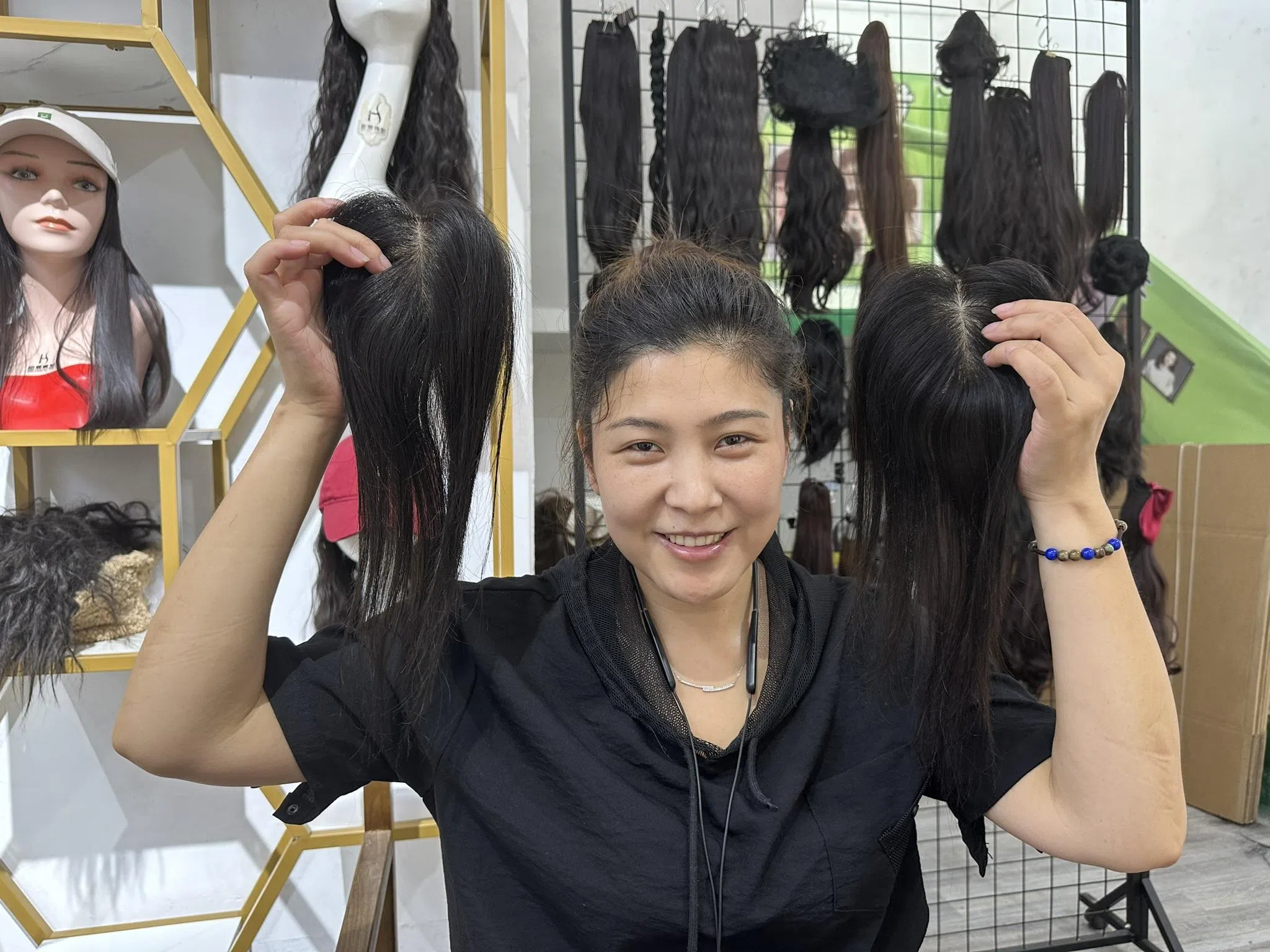 许昌莱源假发工厂店长苗苗向记者展示假发。（林煇智摄）