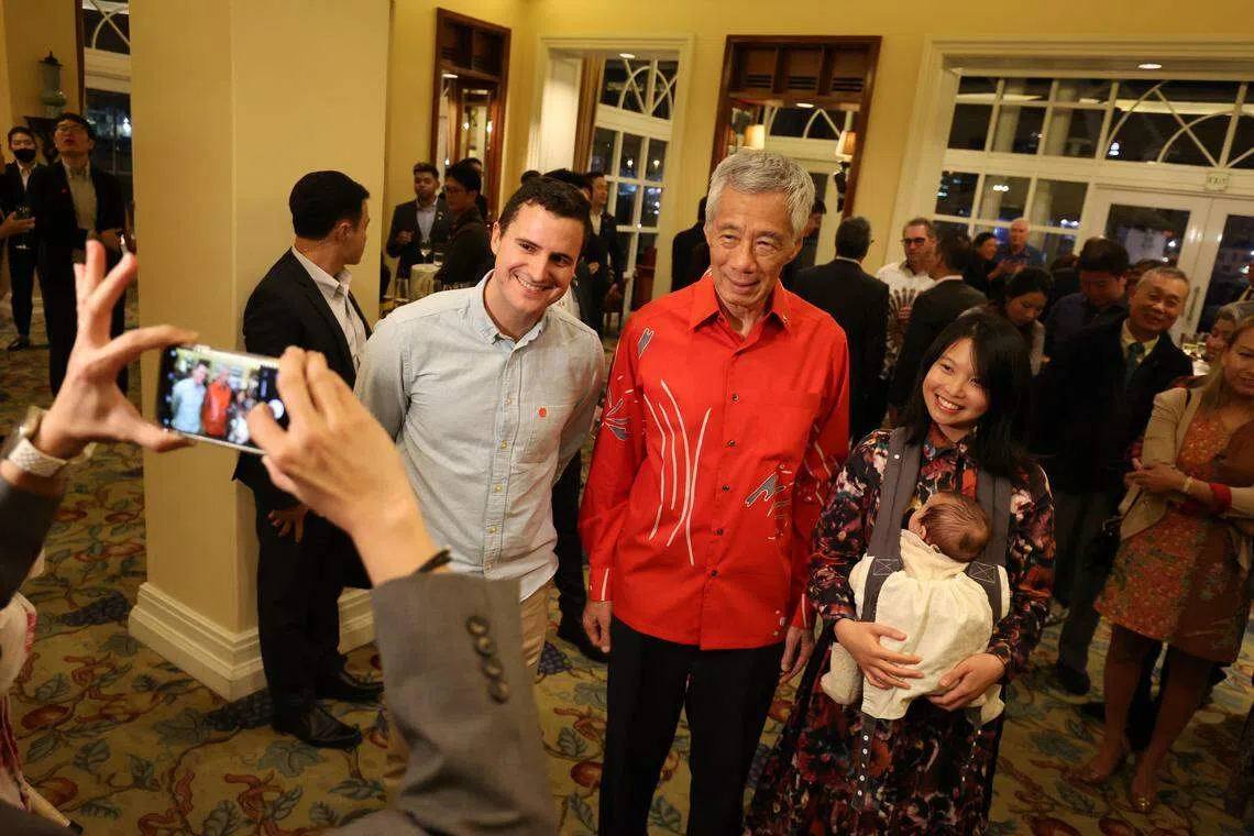 出席招待会的海外新加坡人当中，年纪最小的是抱在妈妈Chloe Duthie（右）怀里的11周大女婴Emma，图为她们与Chloe的丈夫David（左），以及到访的李显龙总理合影的情况。（何家俊摄）