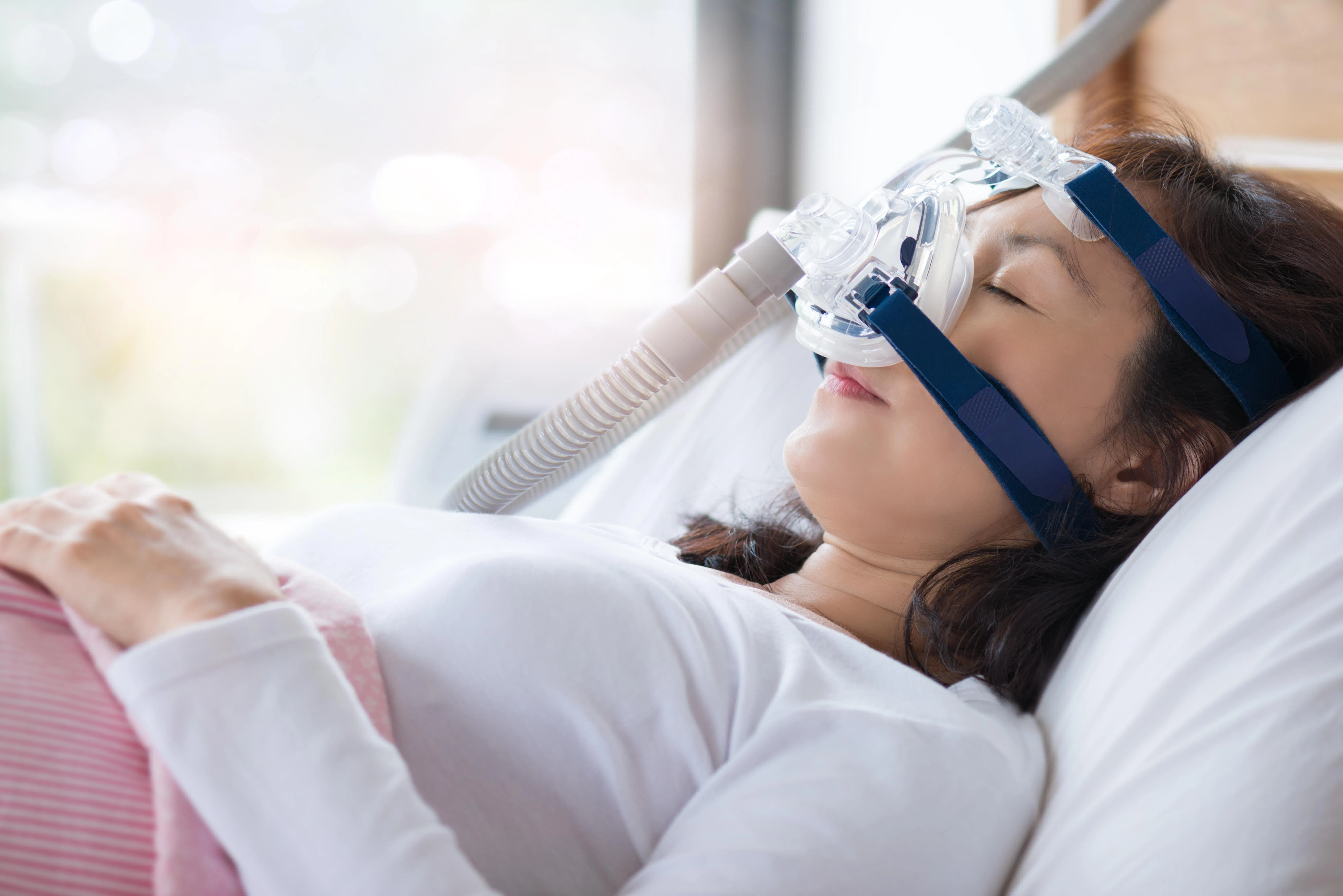 睡眠呼吸暂停症患者在睡觉时佩戴持续气道正压仪器。（iStock图）