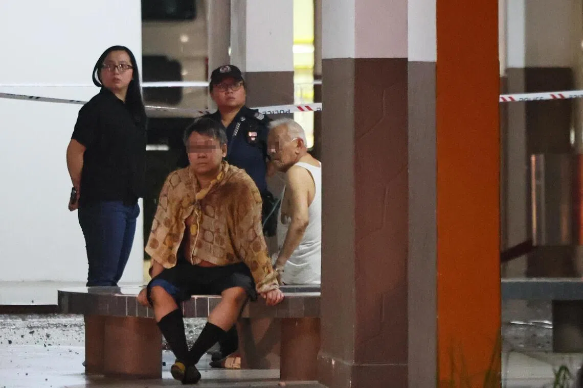 失火单位的父子逃出火海，事后坐在组屋楼下。（档案照片）