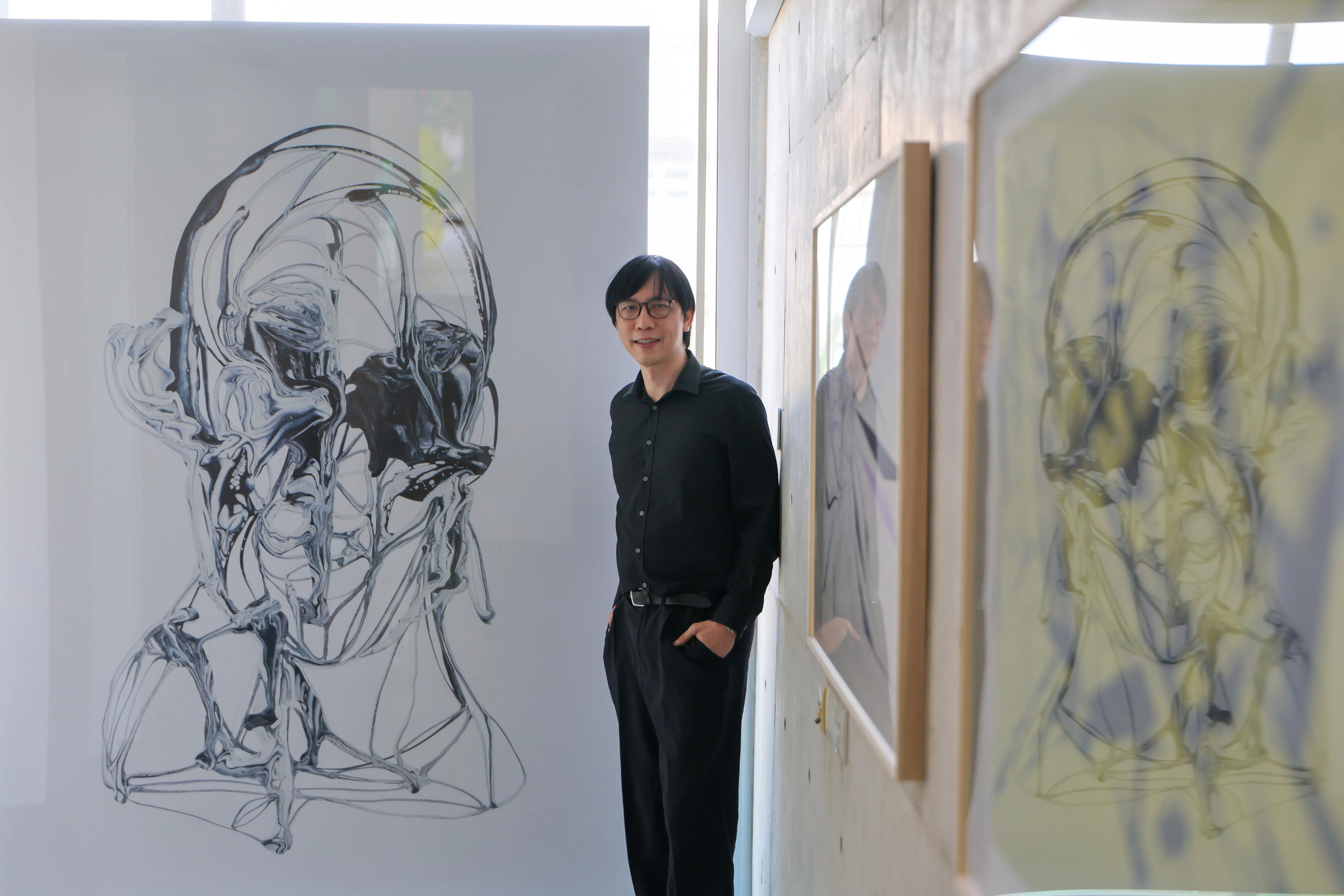 庄乃维医生与表现人类情感的数码绘画作品《焦虑》等合影。（龙国雄摄）
