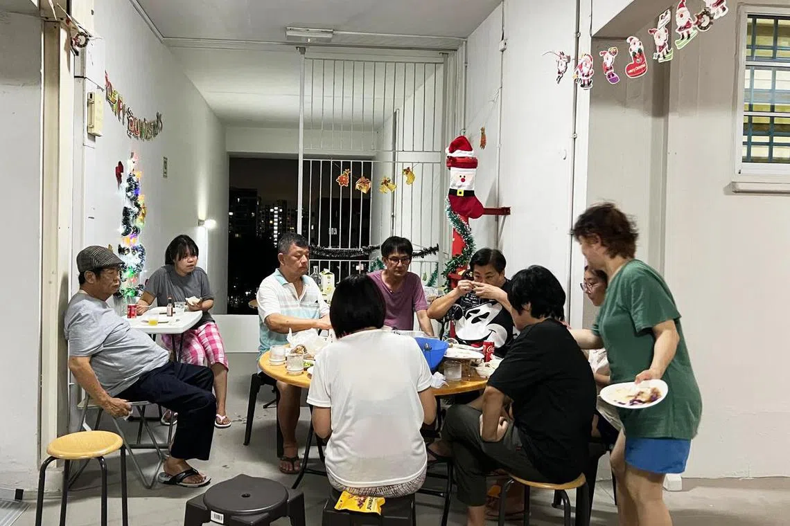 林树发和邻居在组屋走廊摆上一张圆桌，大家带上各自准备的家常菜，聚在一起共度圣诞夜。（受访者提供）